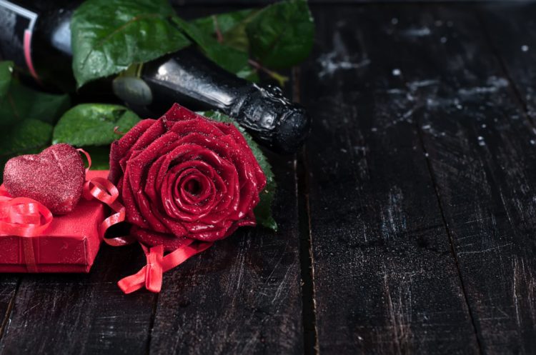 Valentine's day roses and champagne over dark background